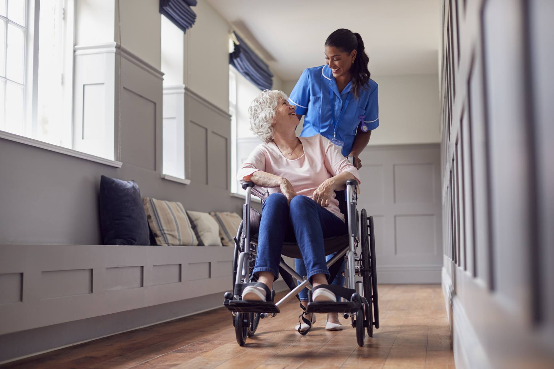 senior-woman-at-home-being-pushed-in-wheelchair-by-2022-04-04-21-35-55-utc (1)